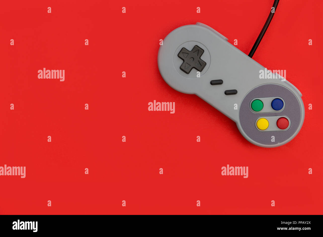 Retro Video Game Controller auf rotem Hintergrund Stockfoto