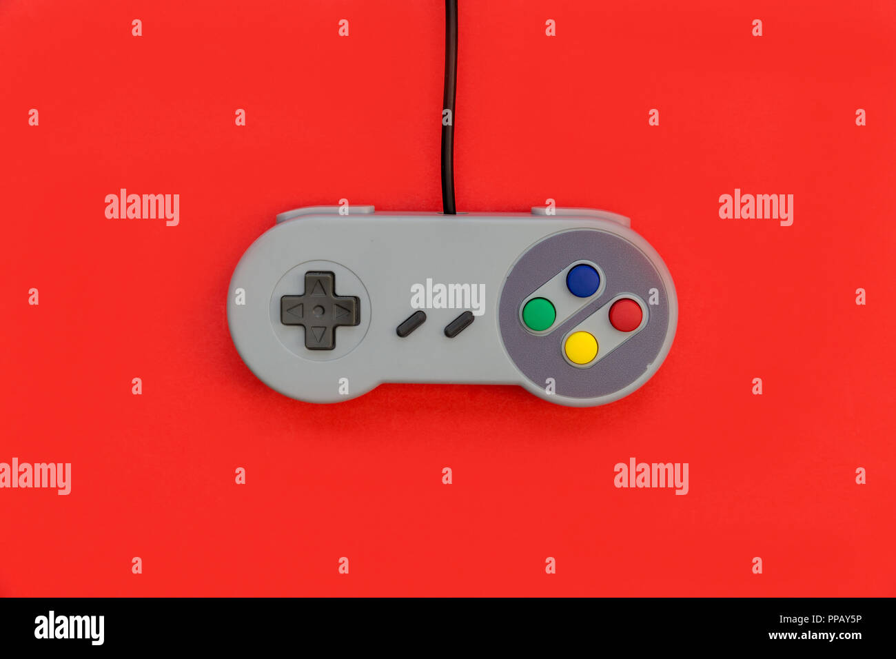 Retro Video Game Controller auf rotem Hintergrund Stockfoto