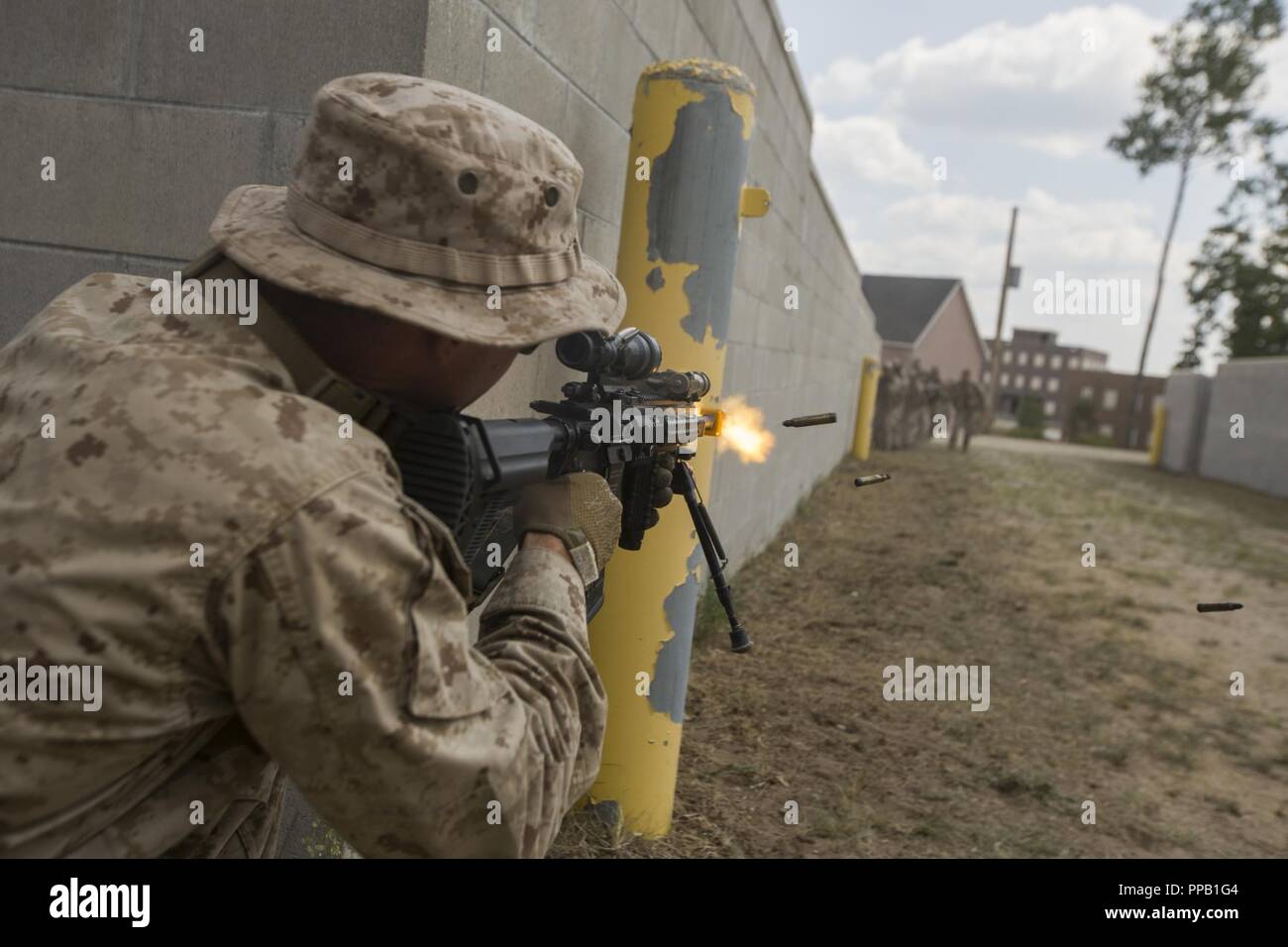 Us Marine Lance Cpl. Matt Mason, eine automatische rifleman mit Bravo Company, 1.Bataillon, 24 Marine Regiment, Brände Leerzeichen an die lettische Soldaten bei einem städtischen Betrieb zwischen Marines und Letten Soldaten, während der Übung Northern Strike im Camp Äsche, Mich., 12.08.2018. Marines mit 1/24 als Opposition Kräfte durch die Dauer der Übung Northern Strike serviert, eine Übung, die vereint Service Mitglieder aus mehreren Niederlassungen, die Staaten und die Koalition Länder zusammen Boden- und Kampfhandlungen durchzuführen. Stockfoto