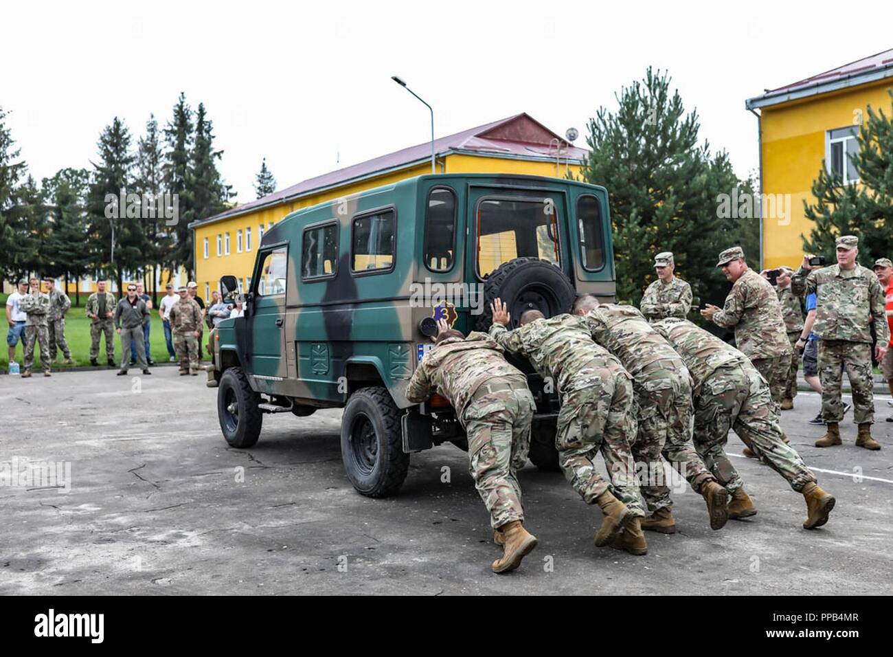 Ein US-Team drückt ein Fahrzeug an einem Wettbewerb während der Polnischen Streitkräfte Tag an Yavoriv, Ukraine, 12.08.15. Stockfoto