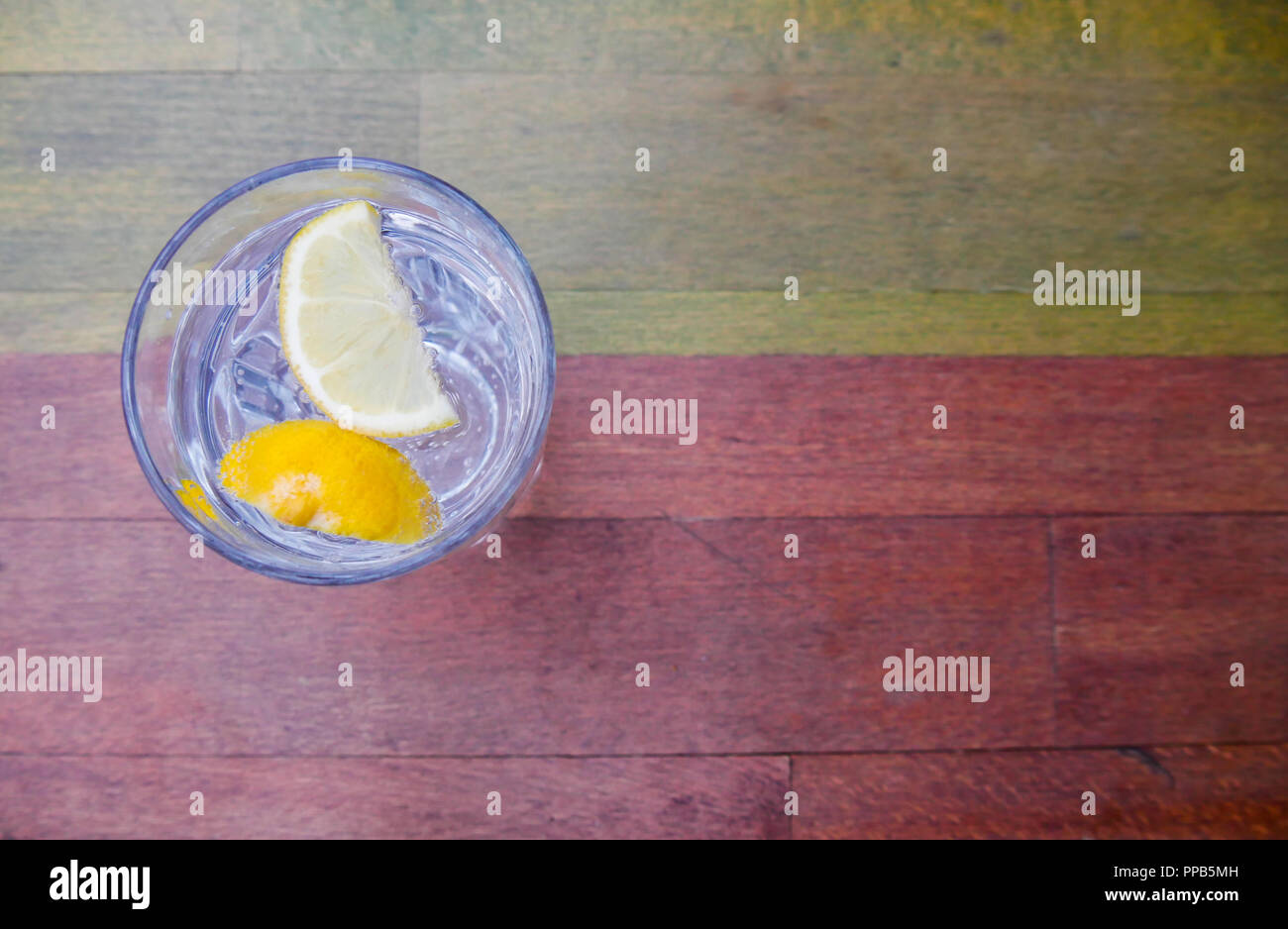 Glas funkelnde Wasser mit Zitronenscheiben auf Tisch Stockfoto