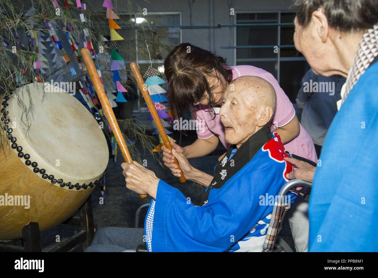 Eine Kinjuen Nursing Home resident spielt das Schlagzeug in Stadt Iwakuni, Japan, August 14, 2018. Ein Bon Odori Festival war am Pflegeheim statt der japanischen Urlaub namens Obon, ein japanischer buddhistischer Custom, ehrt die Geister der Vorfahren vom 12.08.13-16 zu feiern. Stockfoto