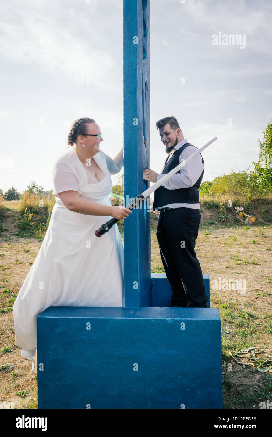 Braut und Bräutigam kämpfen mit Schwertern Stockfoto