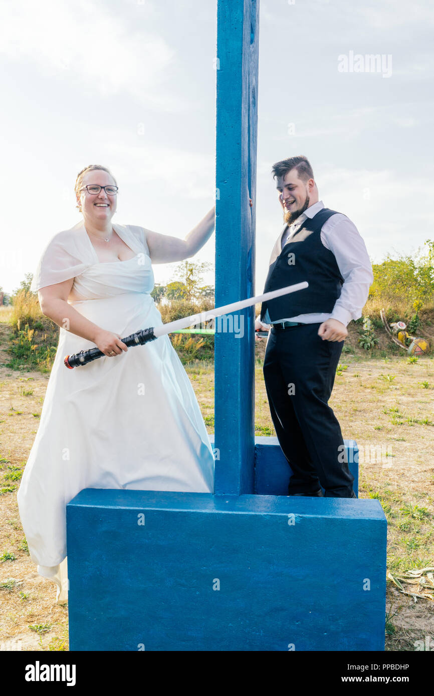 Braut und Bräutigam kämpfen mit Schwertern Stockfoto