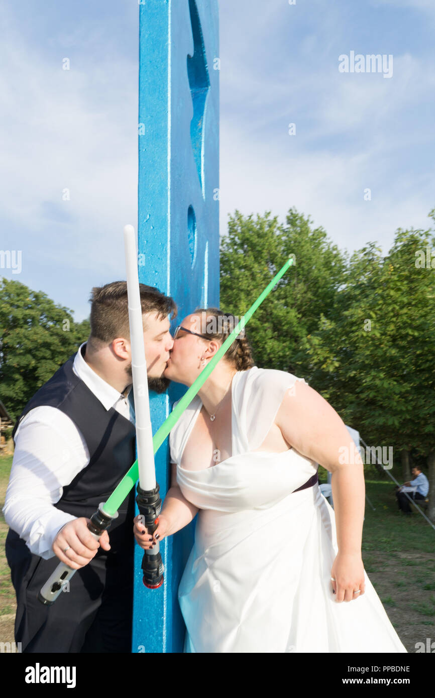 Braut und Bräutigam kämpfen mit Schwertern Stockfoto