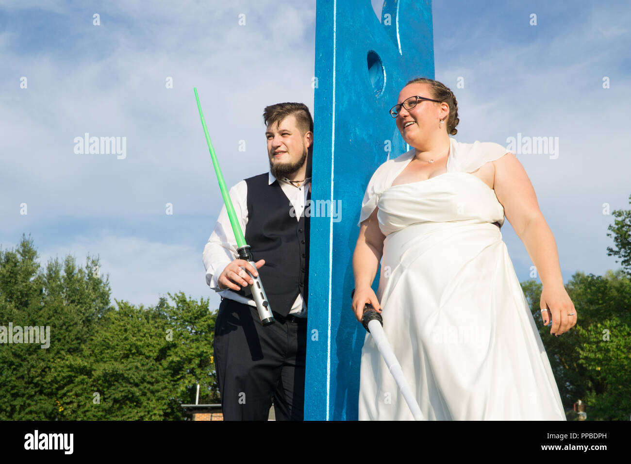 Braut und Bräutigam kämpfen mit Schwertern Stockfoto