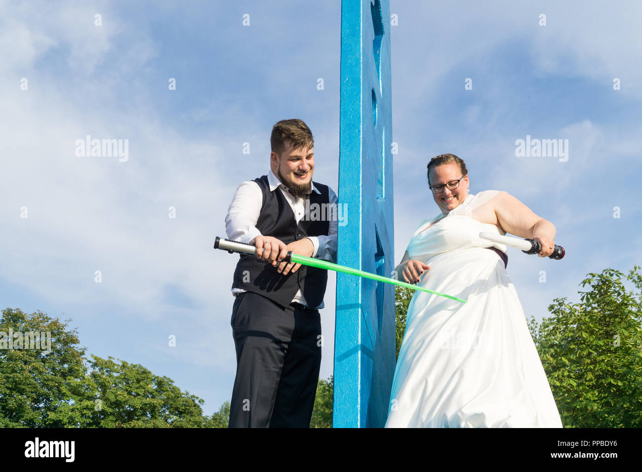 Braut und Bräutigam kämpfen mit Schwertern Stockfoto