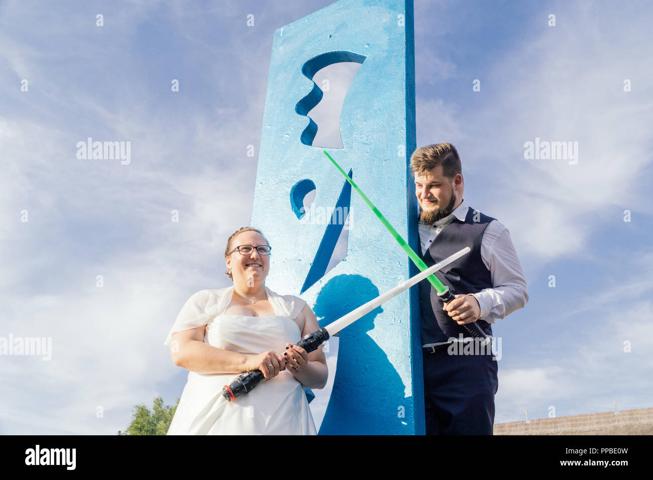 Braut und Bräutigam kämpfen mit Schwertern Stockfoto