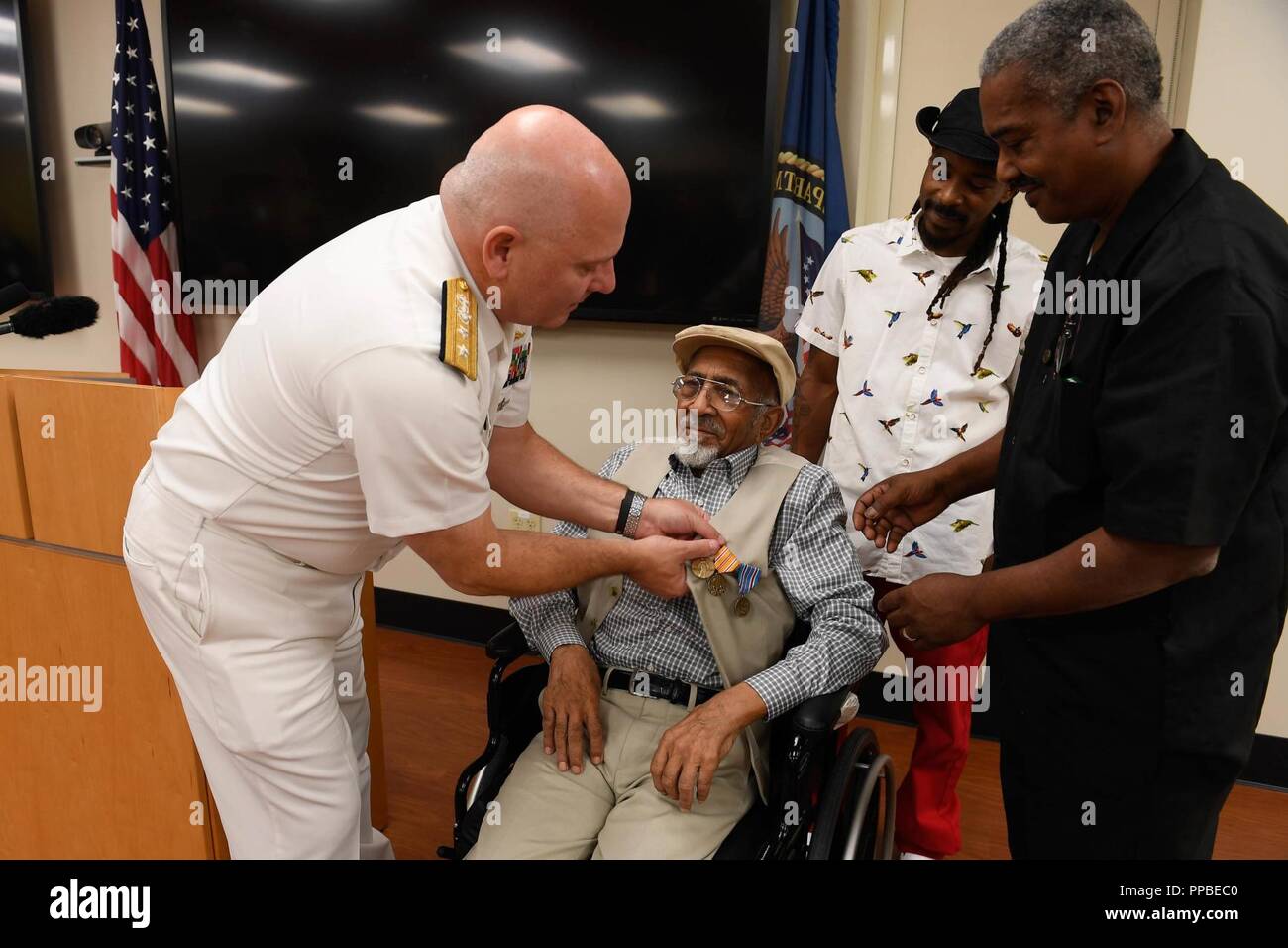 LOUISVILLE, Ky. (Aug. 22, 2018) Hintere Adm. Michael Jabaley, ehemaliger Executive Officer für u-Boote, die Stifte der Asiatic-Pacific Campaign Medal, die World War II Victory Medal und amerikanische Kampagne Medaille auf William Edward Gilbert in Louisville Veterans Affairs Medical Center während der Marine Woche in Louisville, Ky. Die Marine von Community Outreach verwendet die Navy Woche Programm Navy Sailors, Ausrüstung mitbringen und zeigt auf etwa 14 amerikanischen Städten jedes Jahr für eine Woche - lange Zeitplan von outreach Engagements für Amerikaner ausgelegt hautnah zu erleben, wie die US-Marine die Marine ist die n Stockfoto