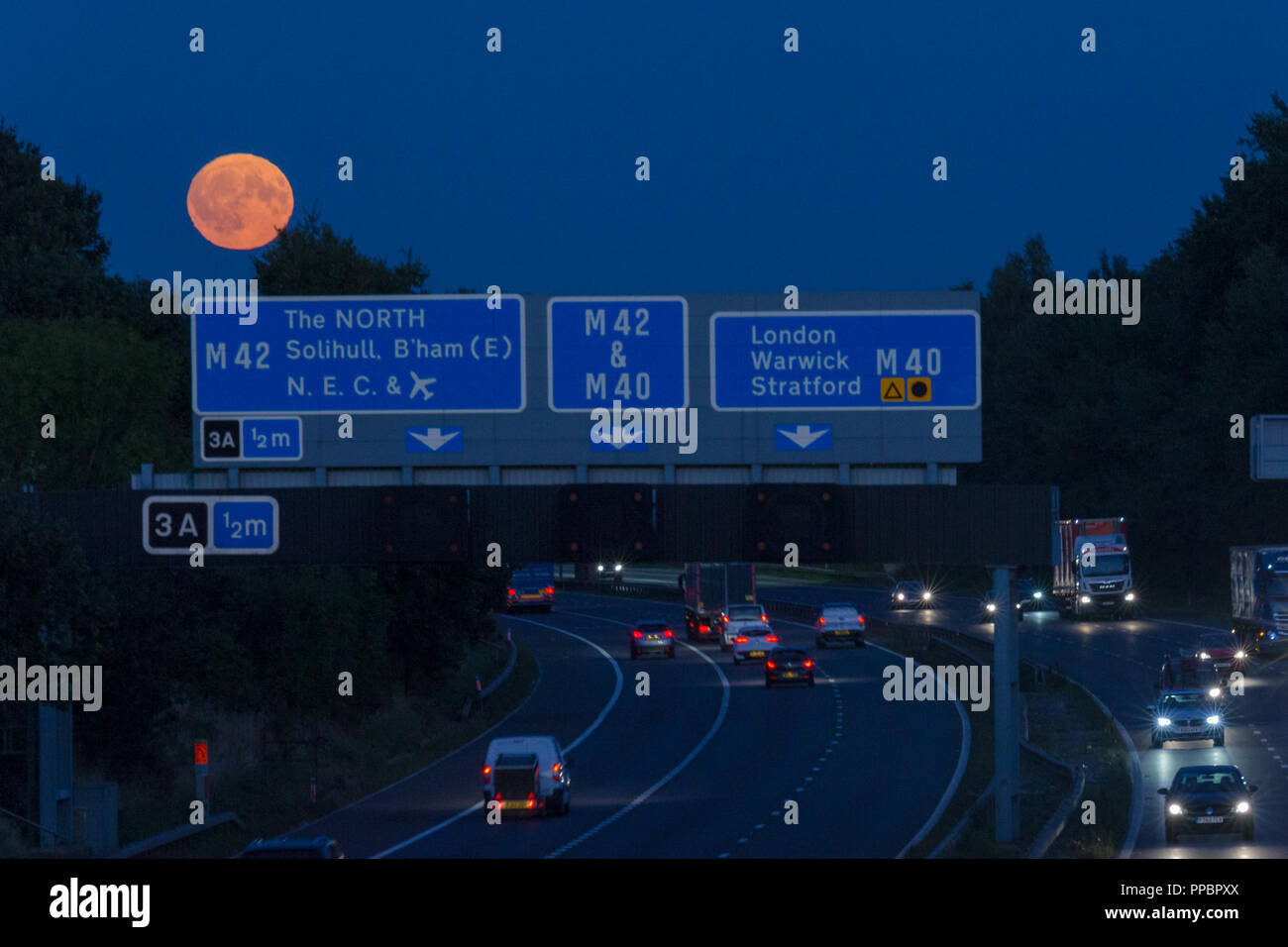 Birmingham, Großbritannien. 24. September, 2018. Die Harvest Moon erhebt sich über der viel befahrenen Autobahn M42 südlich von Birmingham, West Midlands, UK. Peter Lopeman/Alamy Leben Nachrichten. Stockfoto