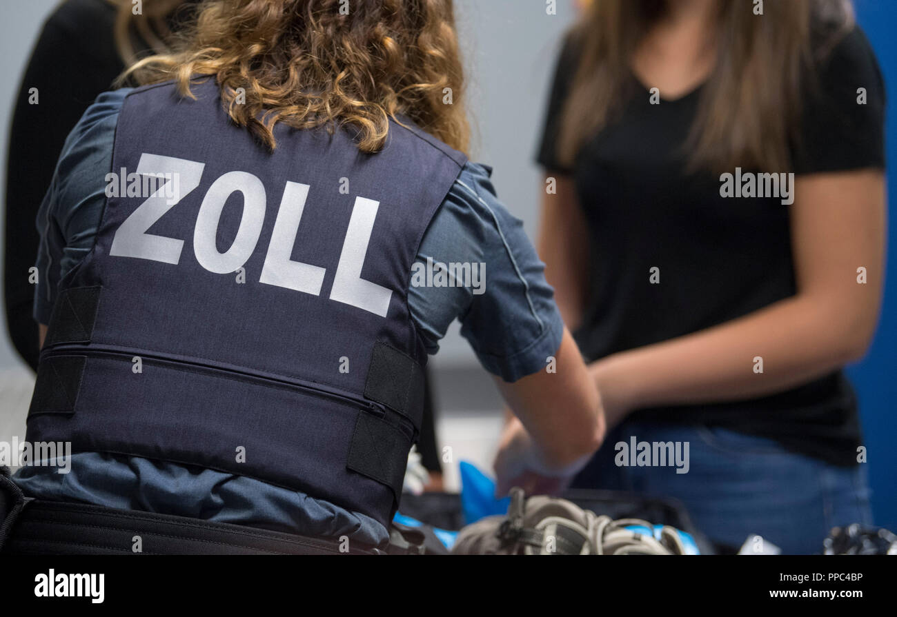 25. September 2018, Hessen, Frankfurt/Main: "Zoll" ist auf der ballistische  Schutzweste von einem Zollbeamten, der die Suche nach dem Gepäck auf einer  Pressekonferenz simuliert Ihr neue Kleider zu präsentieren. In ganz  Deutschland,