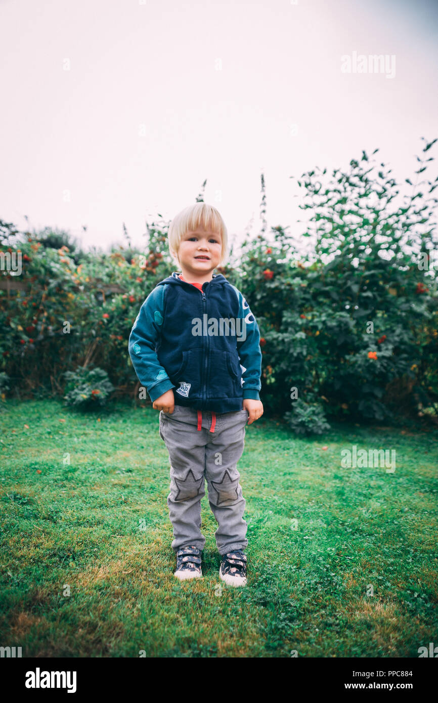 Blonde junge stehend auf Gras Stockfoto