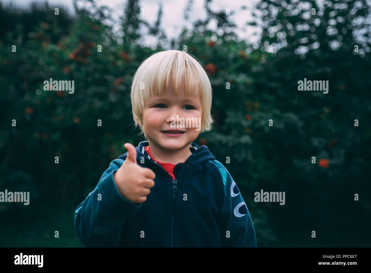 Lächelnde junge blonde Haare braune Augen Daumen hoch Stockfotografie -  Alamy