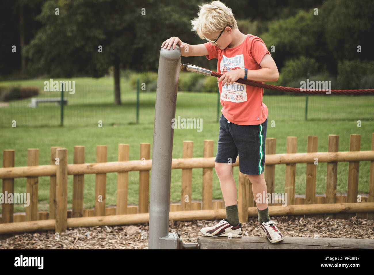 Blonde Junge spielt auf einem Spiel Park Stockfoto