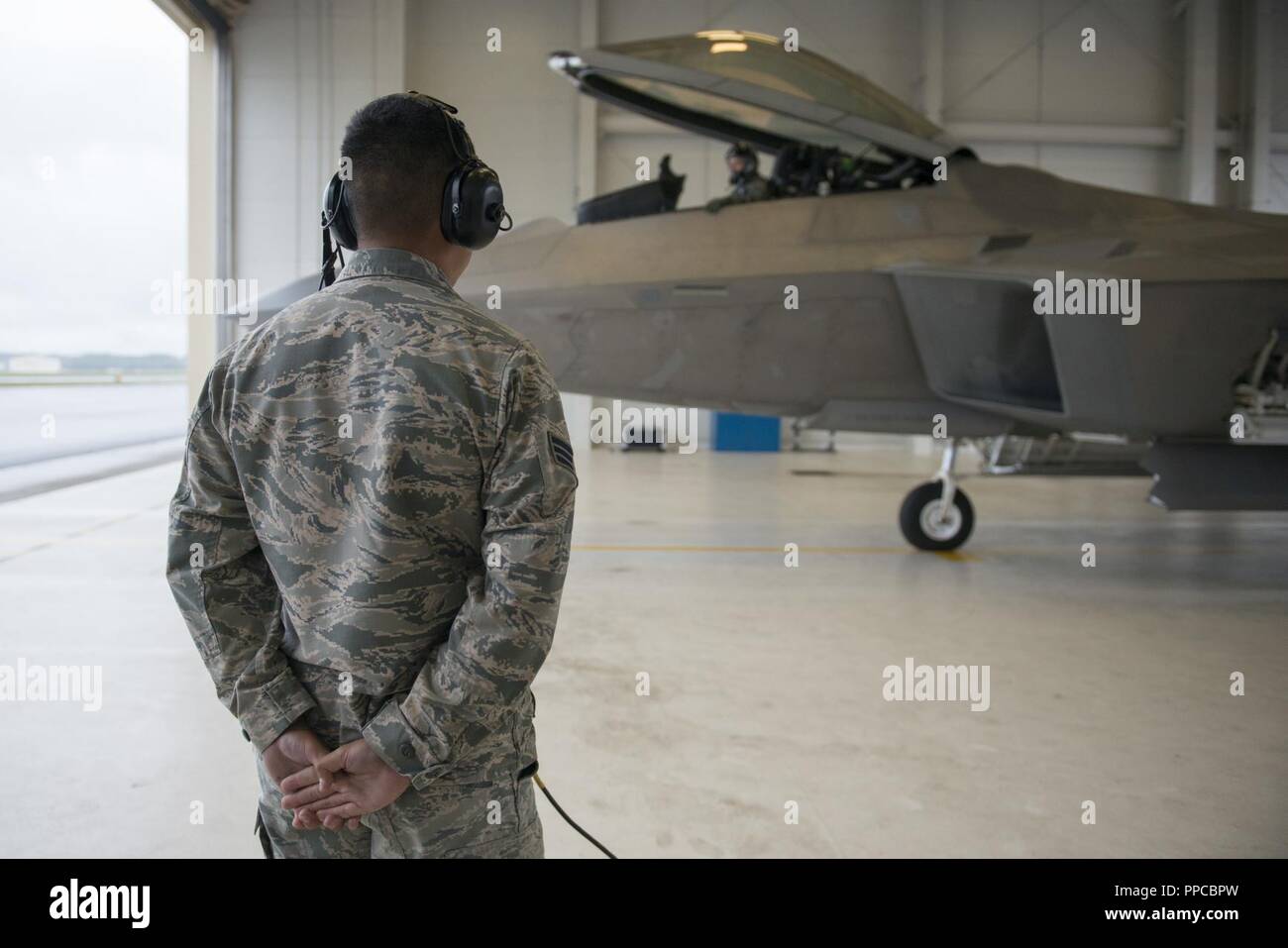 Air Force Senior Airman Roland Reyes, Vordergrund, eine Crew Chief zum 3 Aircraft Maintenance Squadron zugeordnet, wartet als Generalleutnant Ken Wilsbach preflight Verfahren vor seinem letzten Flug als Kommandeur der alaskischen Befehl, Alaskan North American Aerospace Defense Region und Elften Luftwaffe, an Joint Base Elmendorf-Richardson, Alaska, Aug 20, 2018 führt. Wilsbach ist ein Befehl Pilot mit mehr als 5.000 Flugstunden, vor allem in der F-15C, MC-12 und F-22, und hat 71 Einsätze in der nördlichen, südlichen Beobachten und Enduring Freedom geflogen. Stockfoto