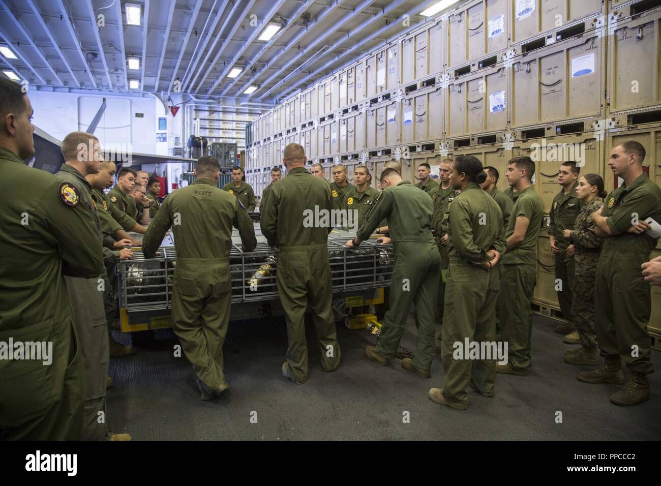 Pazifik - U.S. Marines und Matrosen mit Marine Fighter Attack Squadron 211, 13 Marine Expeditionary Unit (MEU), haben ein Treffen an Bord der Wasp-Klasse amphibisches Schiff USS Essex (LL 2) während des Such- und Rettungsmaßnahmen für eine fehlende Marine am 13. MEU, während einer planmäßigen Einsatz der Essex Amphibious Ready Group (ARG) und 13 MEU, 12. August 2018. Das Essex ARG/13 MEU ist derzeit auf dem Siebten Flotte Bereich der Operationen eingesetzt. Stockfoto