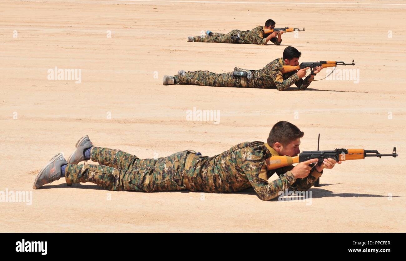 Mitglieder der Manbij militärischen Rat lag in der Bauchlage, wieder Feuer simulieren während einer Ausbildung Szenario in Manbij, Syrien, 16. August 2018. Während der Übung, Mitglieder der MMC praktizierte reagieren zu kontaktieren, Bounding und anderen individuellen Bewegung Techniken. Stockfoto