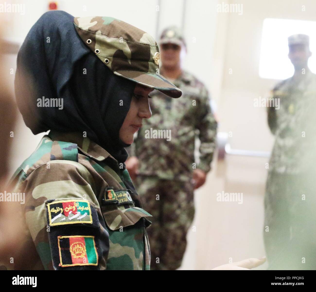 KABUL, Afghanistan (29 August 2018) - Sofia, eine nationale afghanische Armee Soldat, erhält ein Zertifikat, das während der abschlussfeier von der afghanischen nationalen Armee Sergeant Major Akademie am Lager Qurgha, Afghanistan, August 29, 2018. Sie ordnete an zweiter Stelle aus den 80 Absolventen. Stockfoto