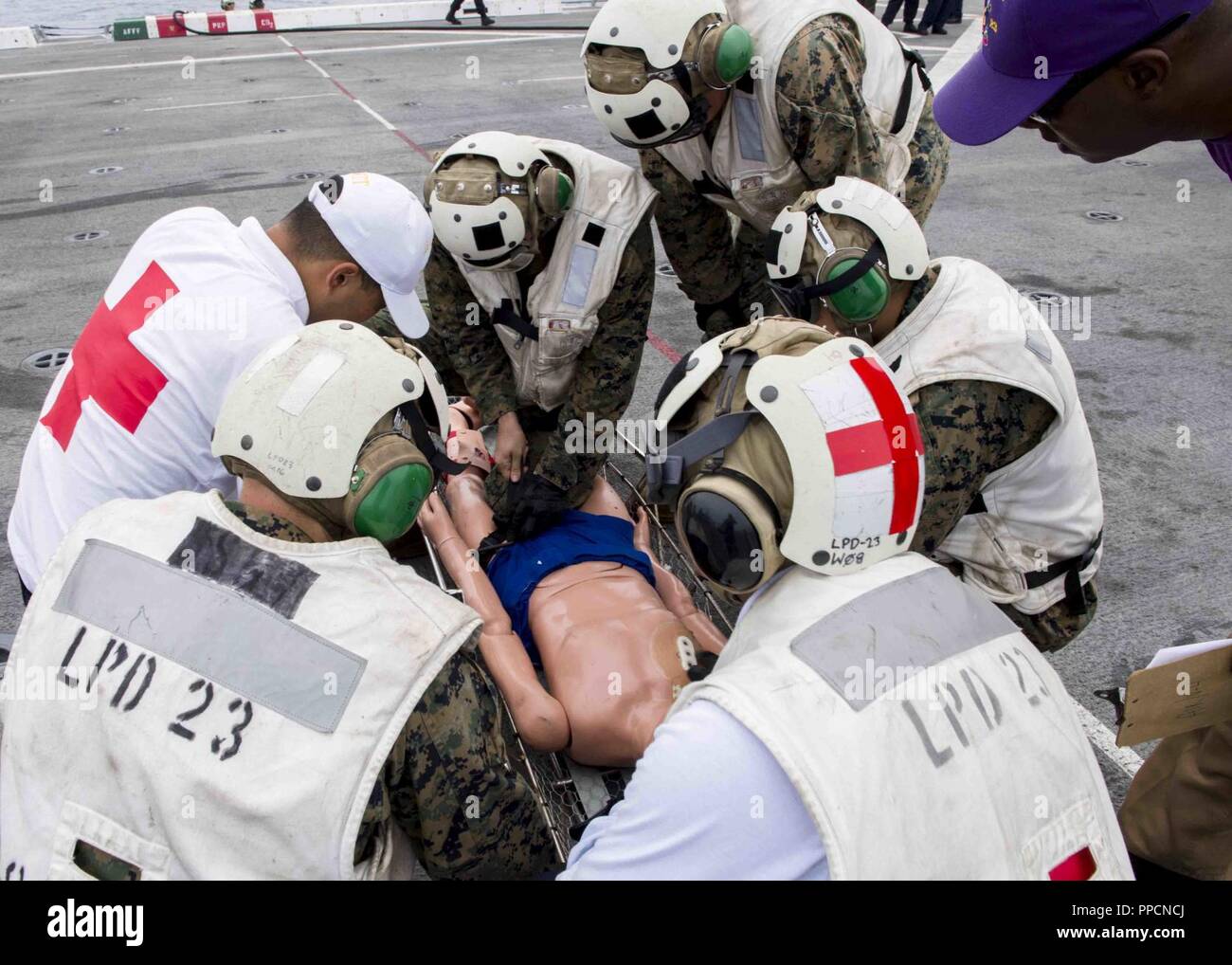 Pazifik (Aug. 15, 2018) Matrosen zu San Antonio zugeordnet - Klasse amphibious Transport dock USS Anchorage LPD (23) und die Marines zugeordnet. bis 13 Marine Expeditionary Unit (MEU) Durchführung medizinischer Notfall Training auf dem Flugdeck während einer planmäßigen Einsatz der Essex Amphibious Ready Group (ARG) und 13 MEU. Das Essex ARG/13 MEU ist ein fähiger und tödliche Navy-Marine Corps Team der 7 Bereich der Flotte im Einsatz der regionalen Stabilität zu unterstützen, Partner und Verbündeten beruhigen und pflegen eine Präsenz posierten auf jede Krise, die von der humanitären Hilfe zu antworten Stockfoto