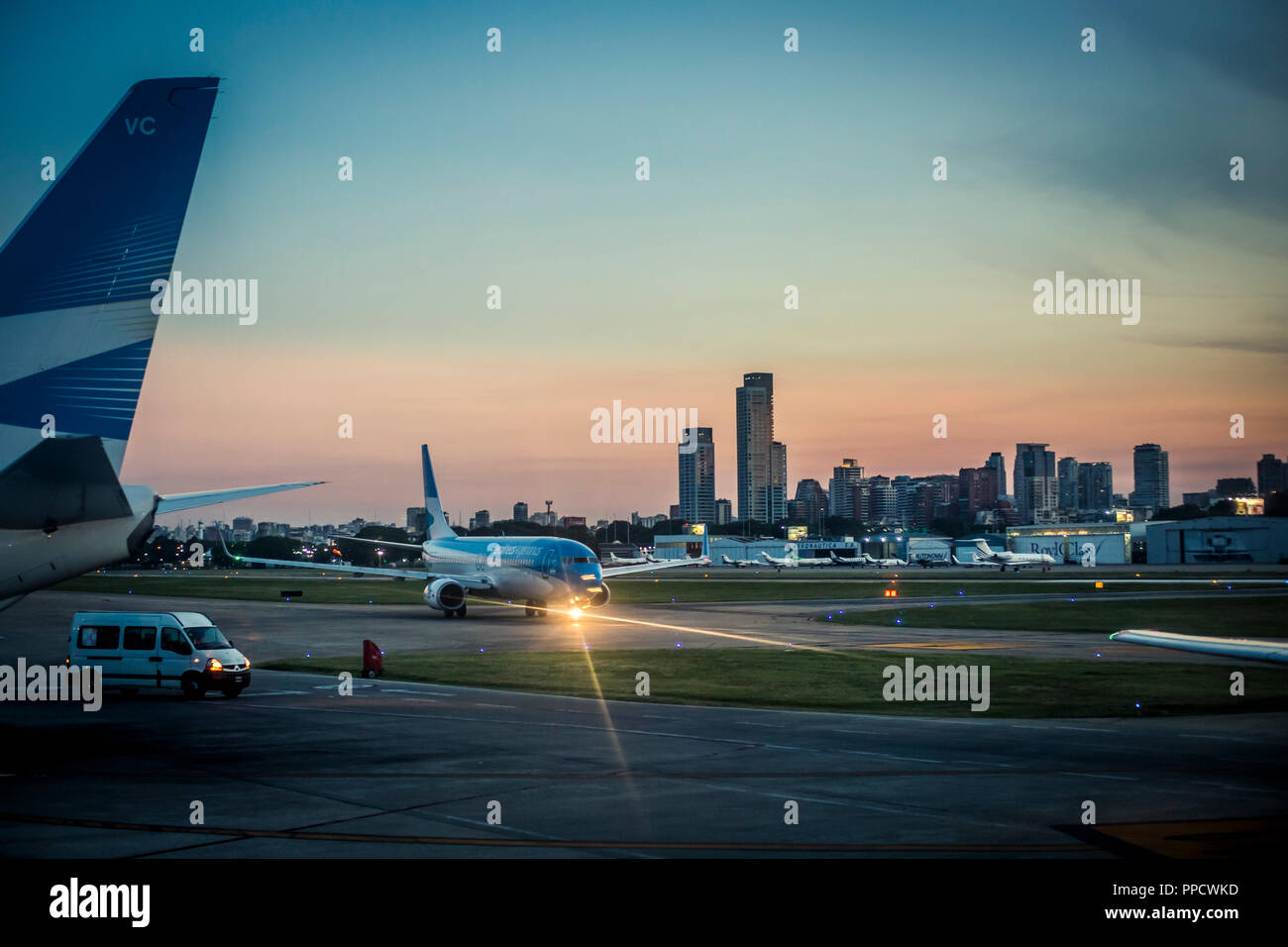 Blick auf Flugzeug am Flughafen Landebahn bei Sonnenuntergang und die Skyline von Buenos Aires, Argentinien Stockfoto