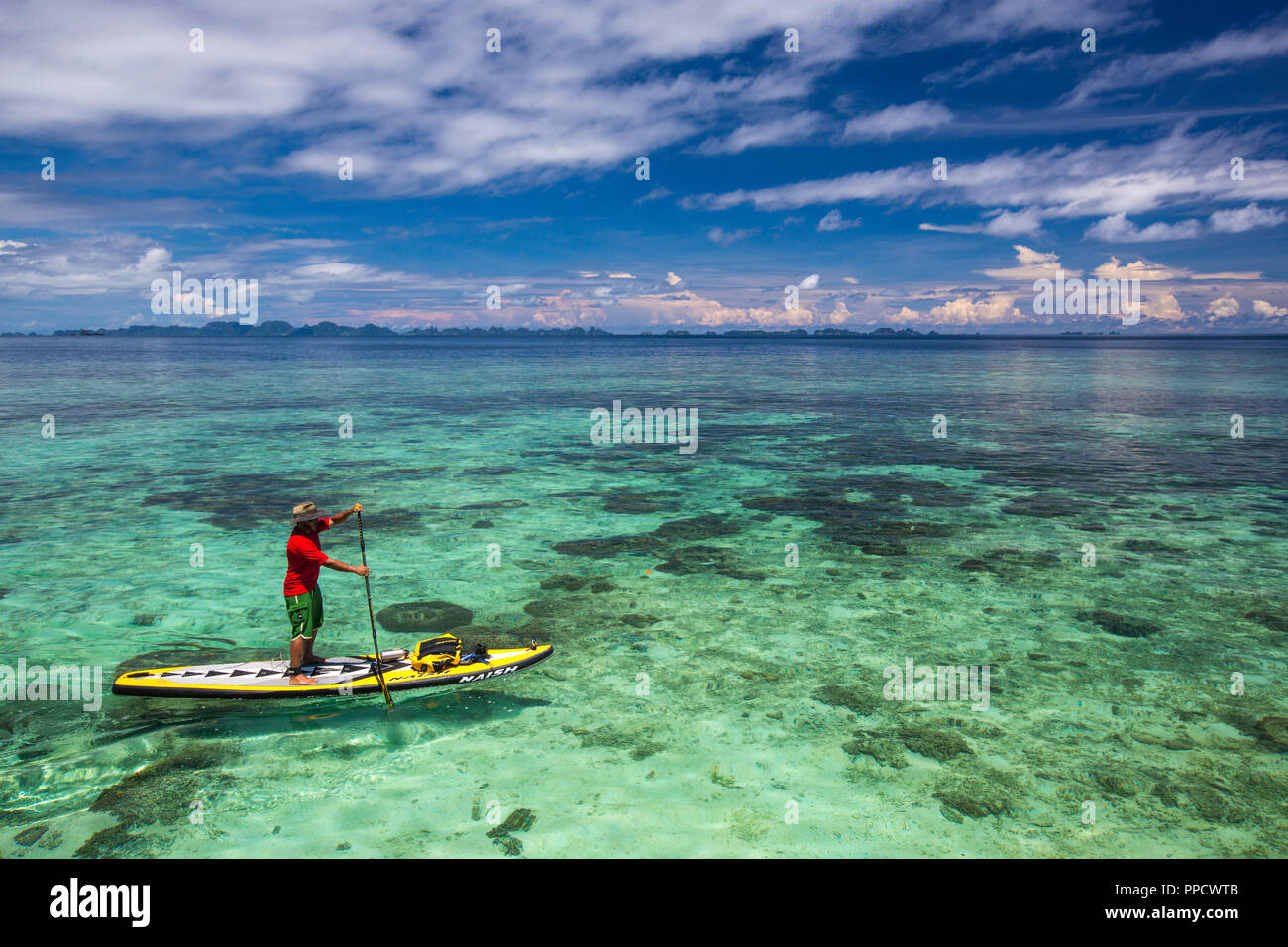 Seitenansicht des Menschen paddleboarding im Meer, Misool, Raja Ampat, Indonesien Stockfoto