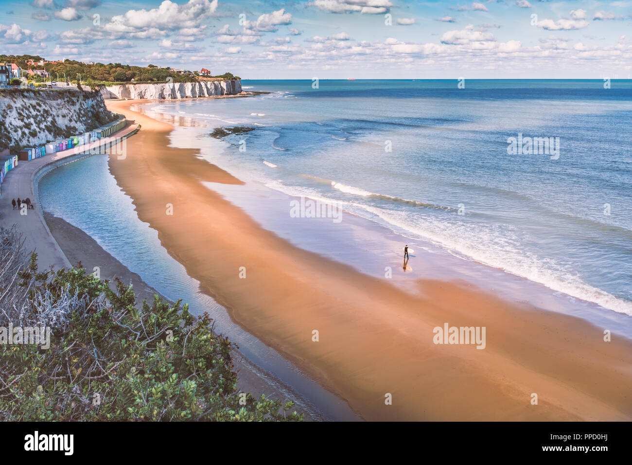 Ebbe in Stein Bay, Broadstairs, Kent, wie Sommer dreht sich bis Herbst, ein einsamer Surfer am Strand spazieren und eine Familie, die auf der Promenade entlang der Seite der Beac Stockfoto