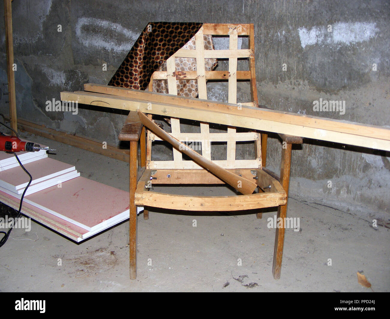 Fotografie mit Szene Reparatur Alte kaputte Sessel im dunklen Keller Stockfoto