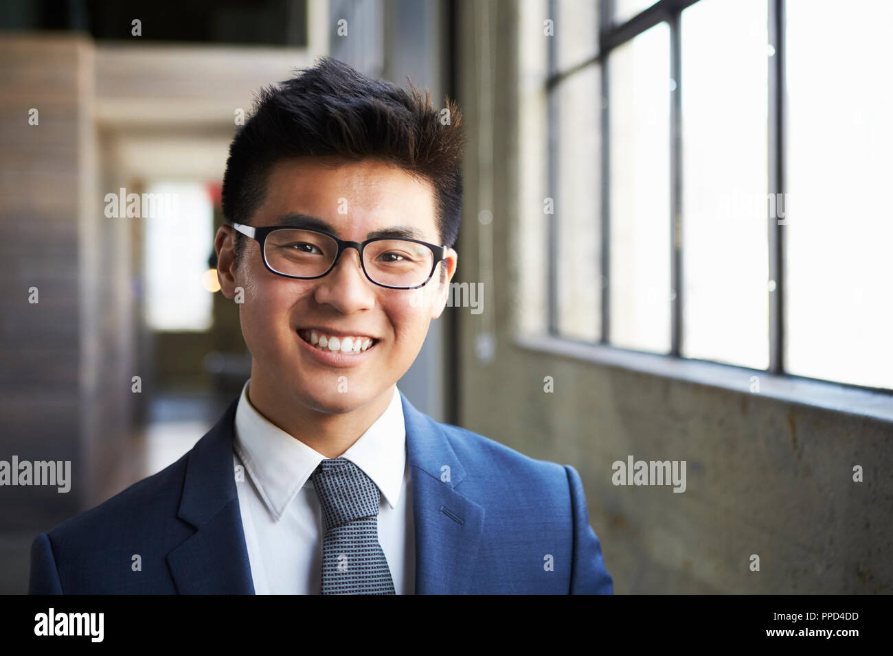 Junge asiatische Geschäftsmann lächelnd in die Kamera Stockfoto