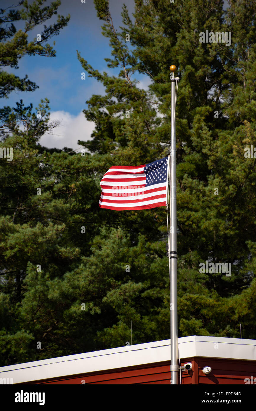 Die Vereinigten Staaten von Amerika Flagge auf Halbmast über dem Volunteer Fire Company in Spekulant, NY USA fliegen Stockfoto