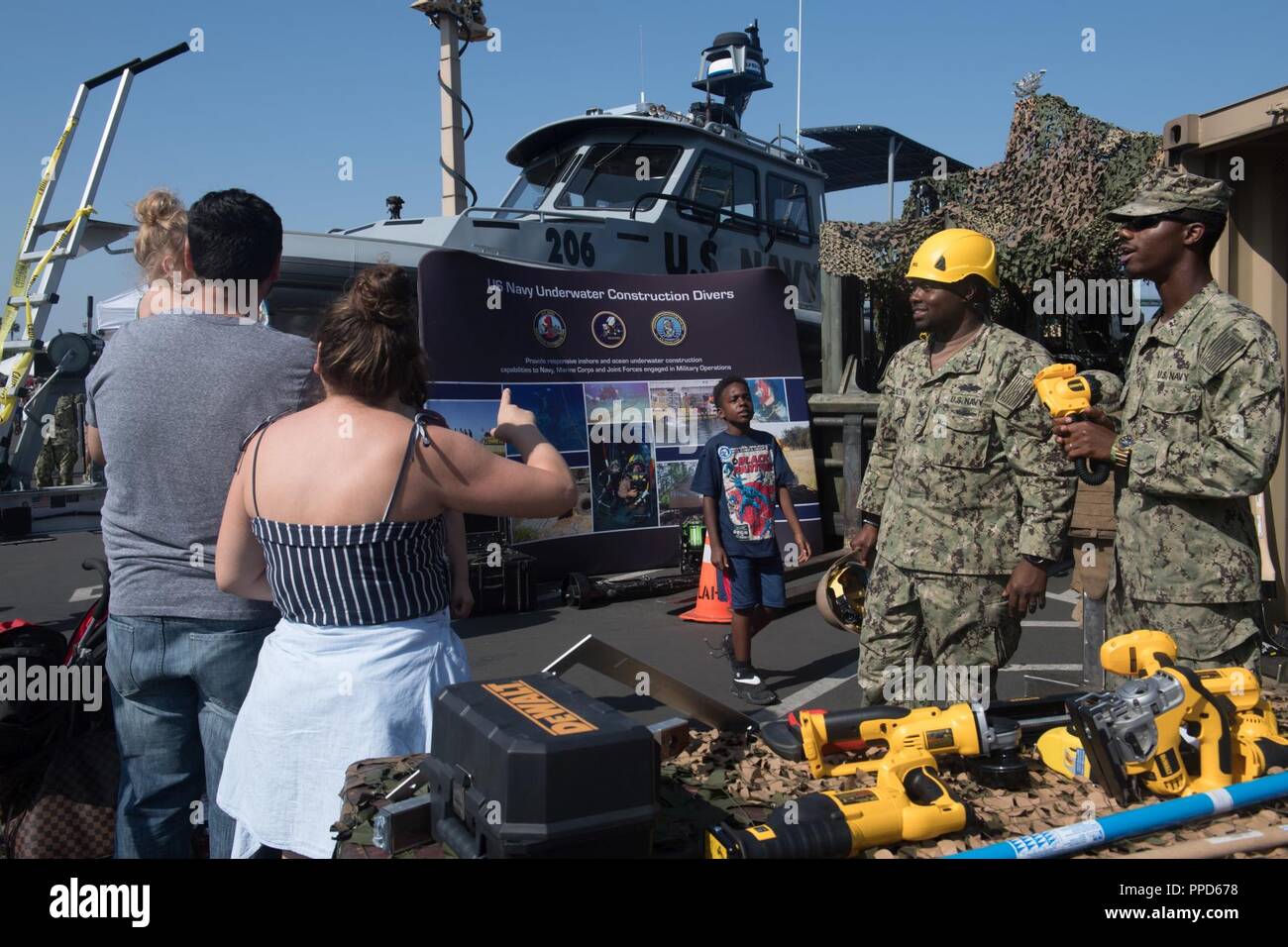 ANGELES (Sept. 2, 2018) Bau Elektriker 1. Klasse Dwayne Watson und Anlagenbediener Constructionman Tyrell Puryear, Bau Bataillon Wartungseinheit 303 angebracht, eine Familie auf das Leben informieren als Seabee bei einer militärischen Display und Demo auf dem Schlachtschiff Iowa Museum während Los Angeles Flotte Woche (LAFW). LAFW ist eine Gelegenheit für die amerikanische Öffentlichkeit die Navy, Marine Corps und Küstenwache Teams zu treffen und America's Meer Dienstleistungen Erfahrung. Während der Fleet Week, service Mitglieder beteiligen sich an verschiedenen gemeinschaftlichen Service Veranstaltungen, Showcase Funktionen und Geräten in die Gemeinschaft Stockfoto