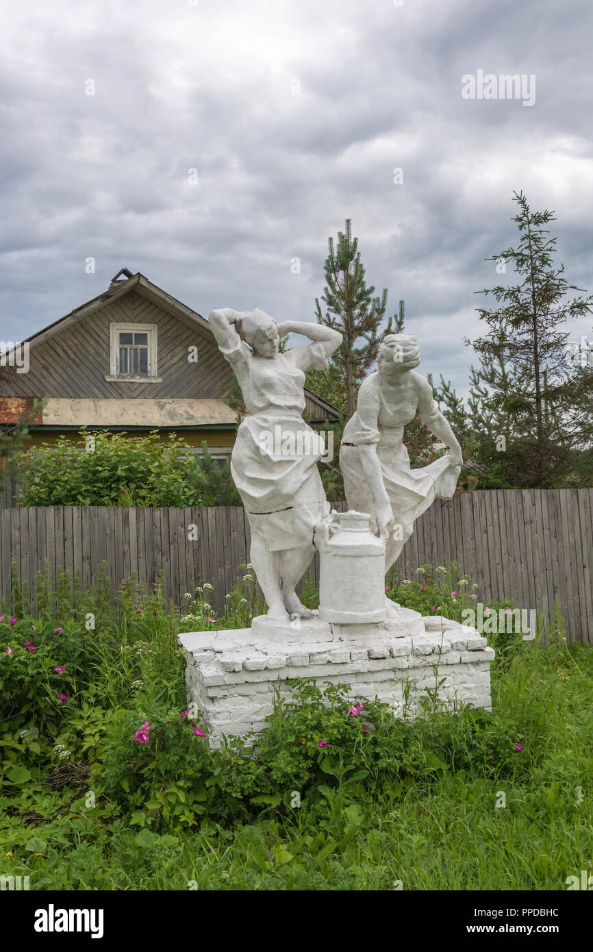 White Skulptur von Landwirtinnen, der trägt einen Krug Milch unter blühenden Wild Rose. Stockfoto