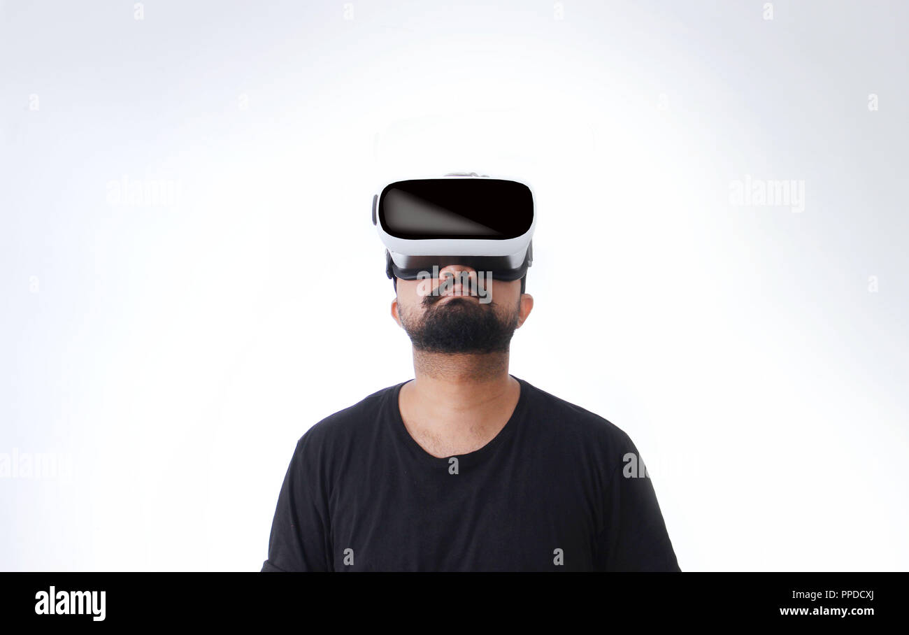 Kerl, der durch VR (Virtual Reality)-Brillen schaut - in die Metaverse - isoliert auf weißem Hintergrund Stockfoto