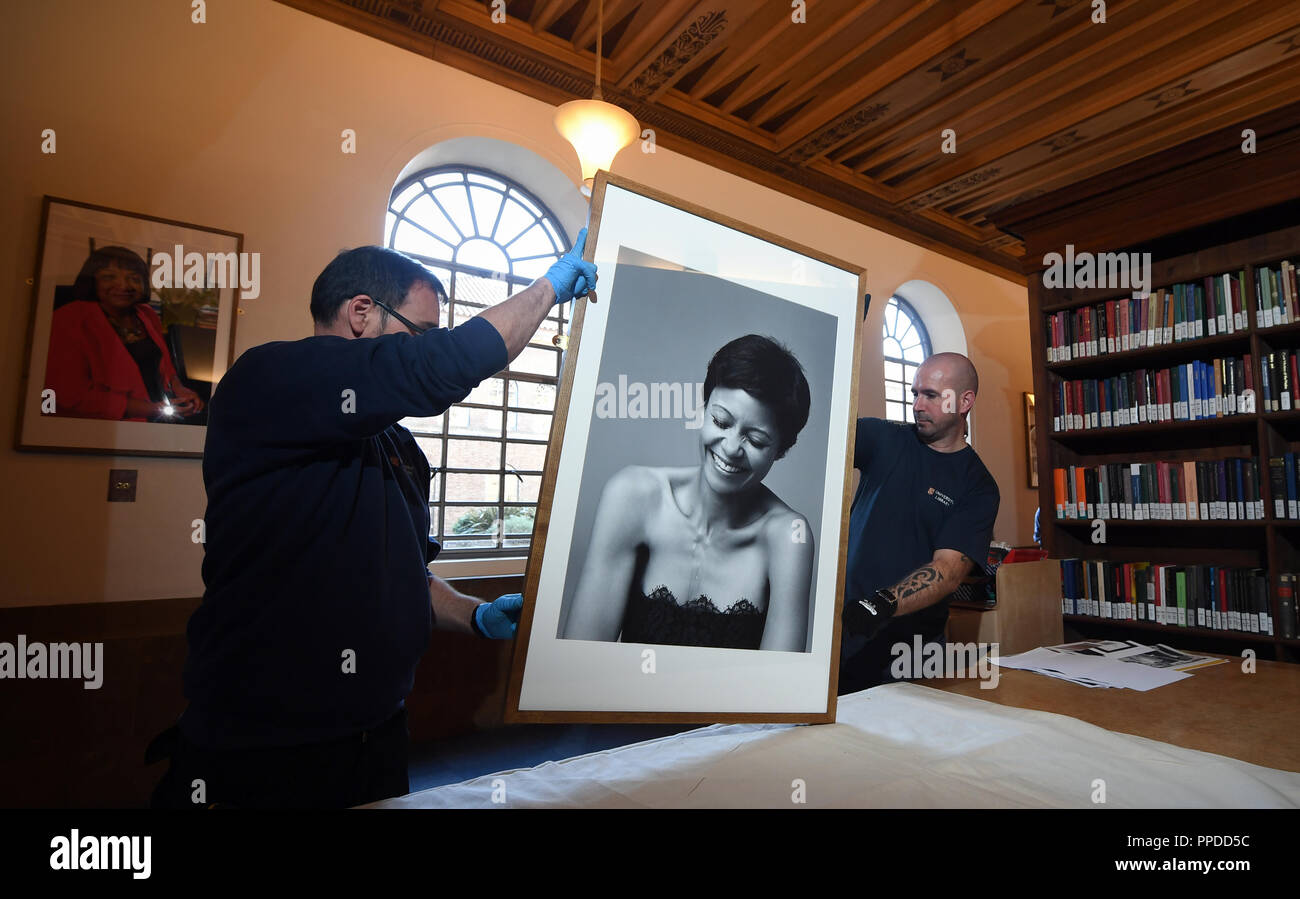 Der Cambridge University Library Schreiner bereiten Sie ein Porträt der Schauspielerin Thandie Newton zu hängen, als Teil der neuen Ausstellung "Schwarze Cantabs: Geschichte der Filmemacher, der sich aus 14 Porträts von schwarz Cambridge Absolventen. Stockfoto
