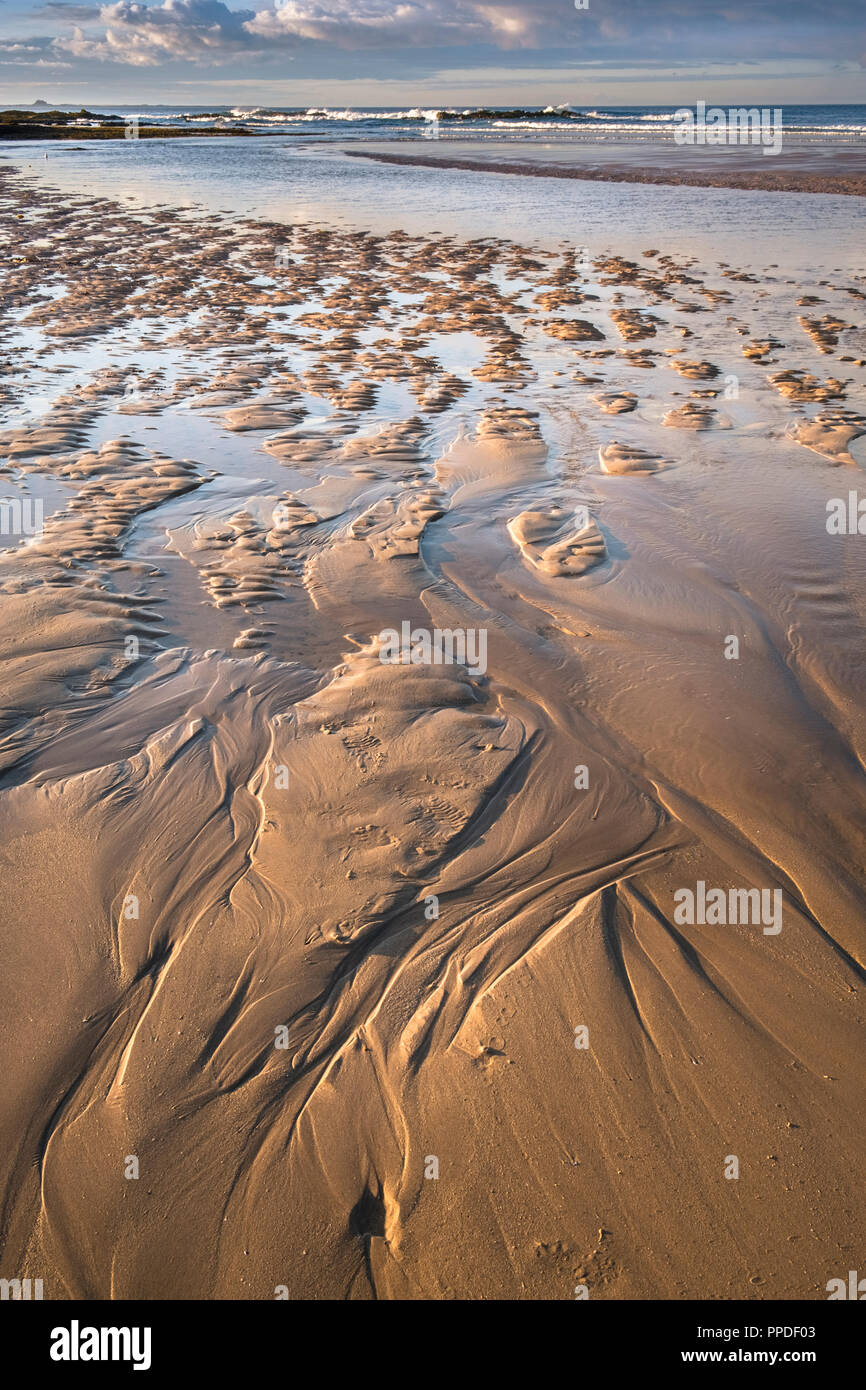 Sand Wellen bei Ebbe auf Bamburgh Strand, Küste von Northumberland, England Großbritannien Stockfoto