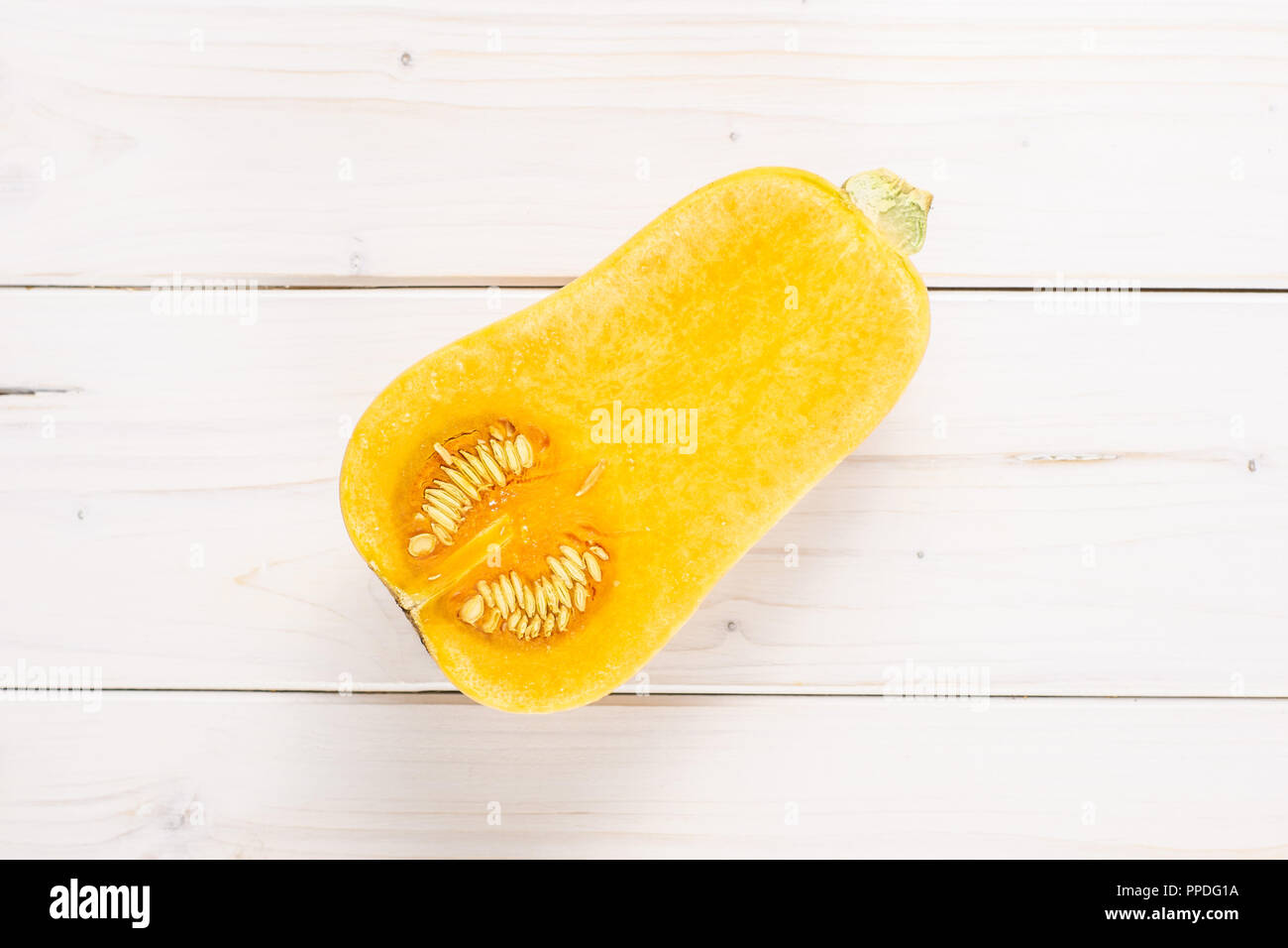 Die eine Hälfte der glatten Birnenförmig orange Kürbis waltham Vielzahl flatlay auf weißem Holz Stockfoto