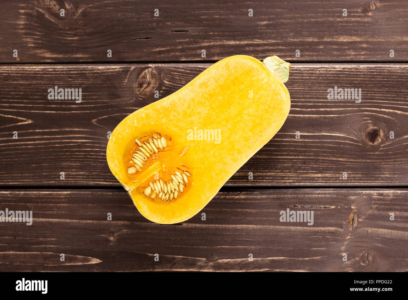 Die eine Hälfte der glatten Birnenförmig orange Kürbis waltham Vielzahl flatlay auf braunem Holz Stockfoto