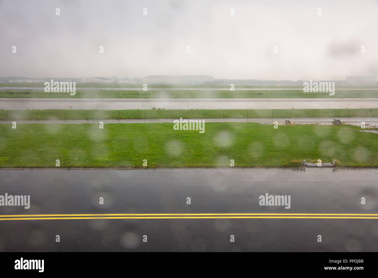Landung am Flughafen Rotterdam Start- und Landebahn an einem regnerischen Tag, Regentropfen auf der Ebene Fenster, Hintergrund. Stockfoto