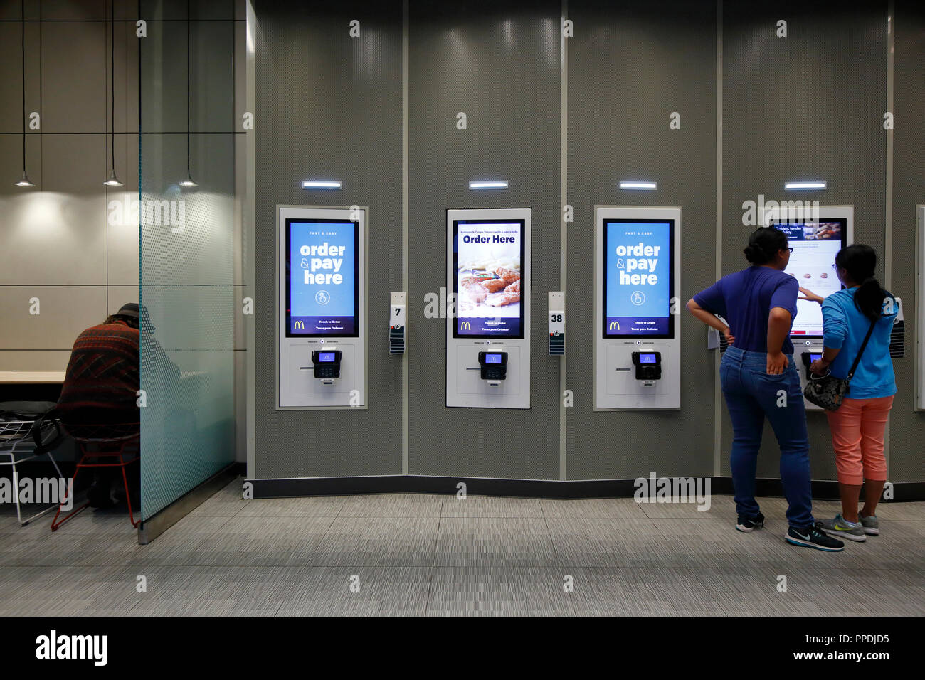 Mitarbeiter an einem digitalen Selbstbedienungs-Bestellkiosks in einem McDonalds Stockfoto
