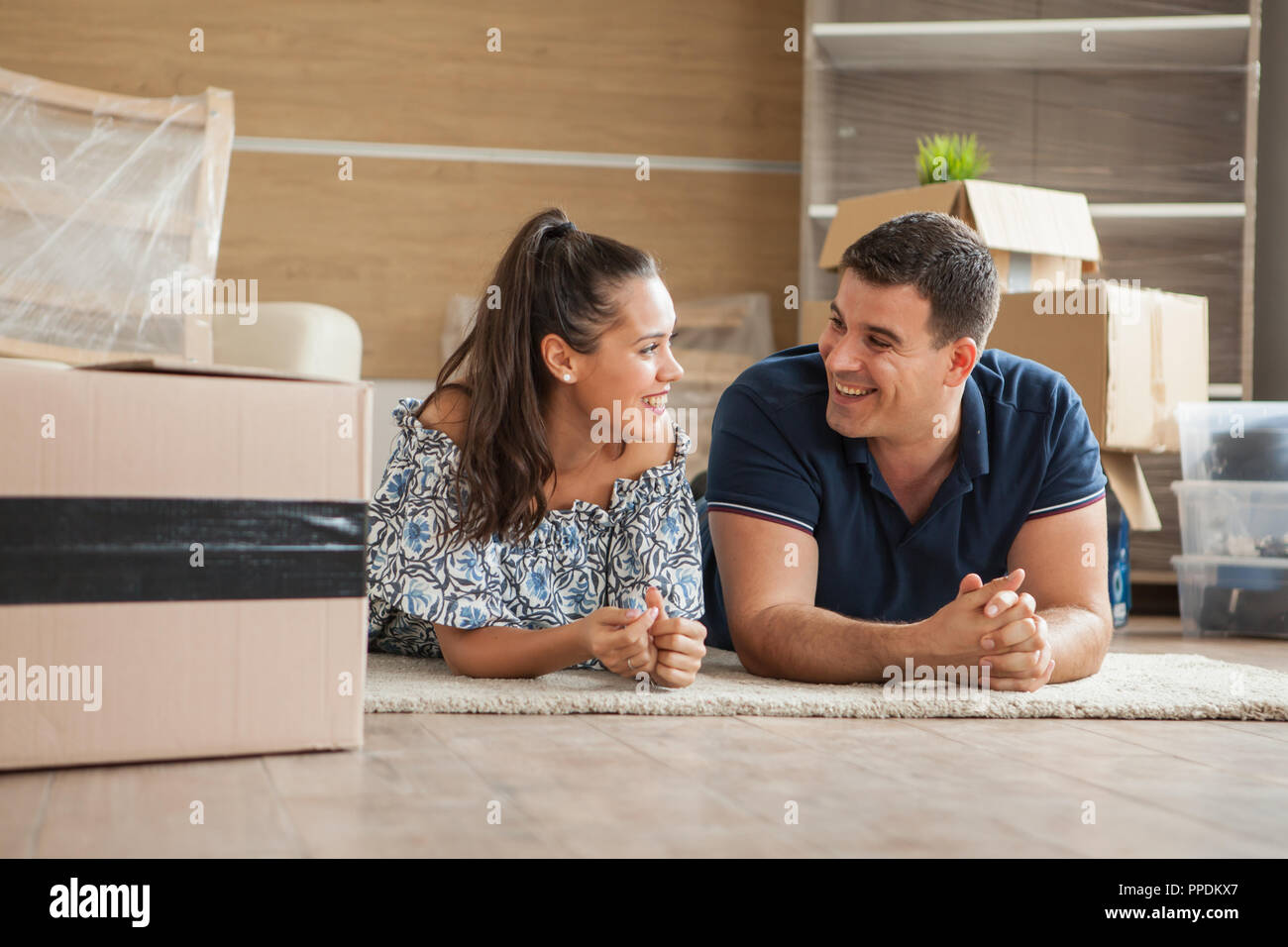Paare, die sich in Haus sitzen auf dem Boden. Freundliche junge Paar Stockfoto