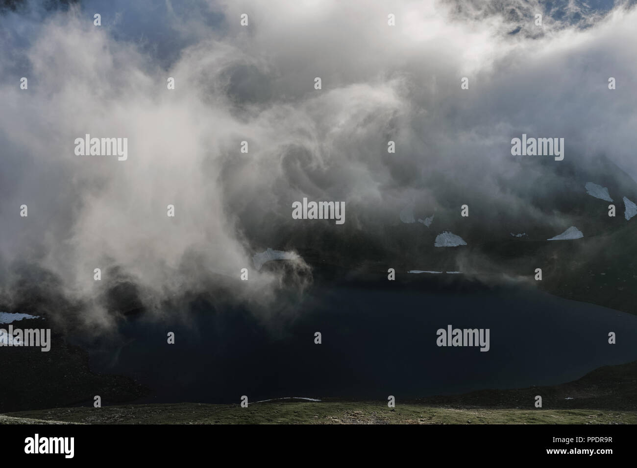 Hang in einer niedrigen Cloud mit einer türkisfarbenen See, eingehüllt in Nebel in einer malerischen Landschaft Landschaft. Bewölkt Idylle Reisen Ruhe ruhig Aer Stockfoto