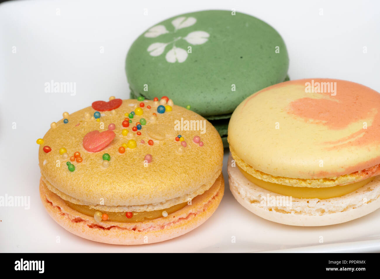 Hausgemachte sortierten Macarons schön mit bunten Herzen, grüner Tee und Gelb und Gold Farbe dekoriert Stockfoto