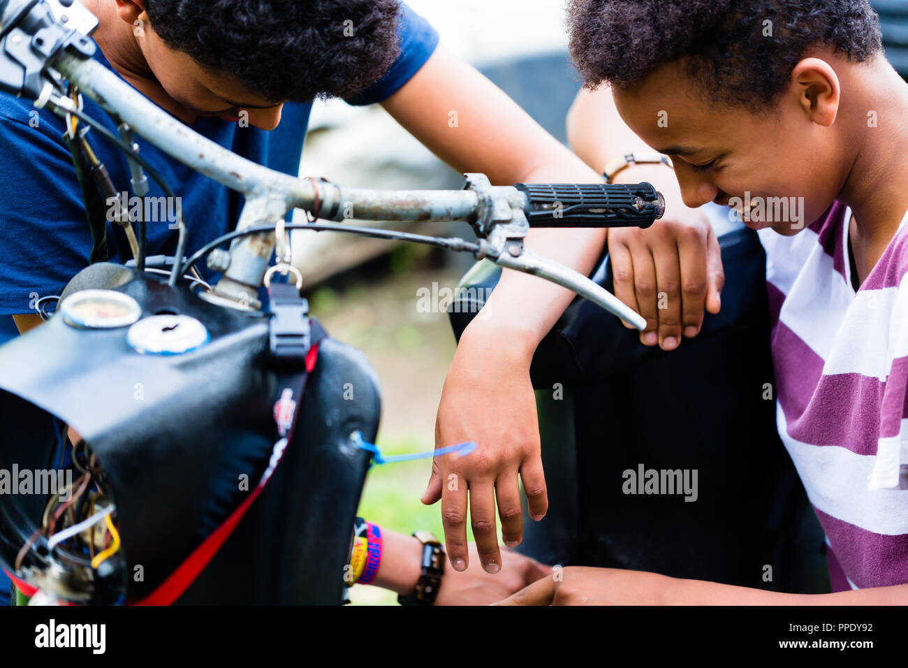 Nahaufnahme der männlichen Freunde am Motorrad Suchen Stockfoto