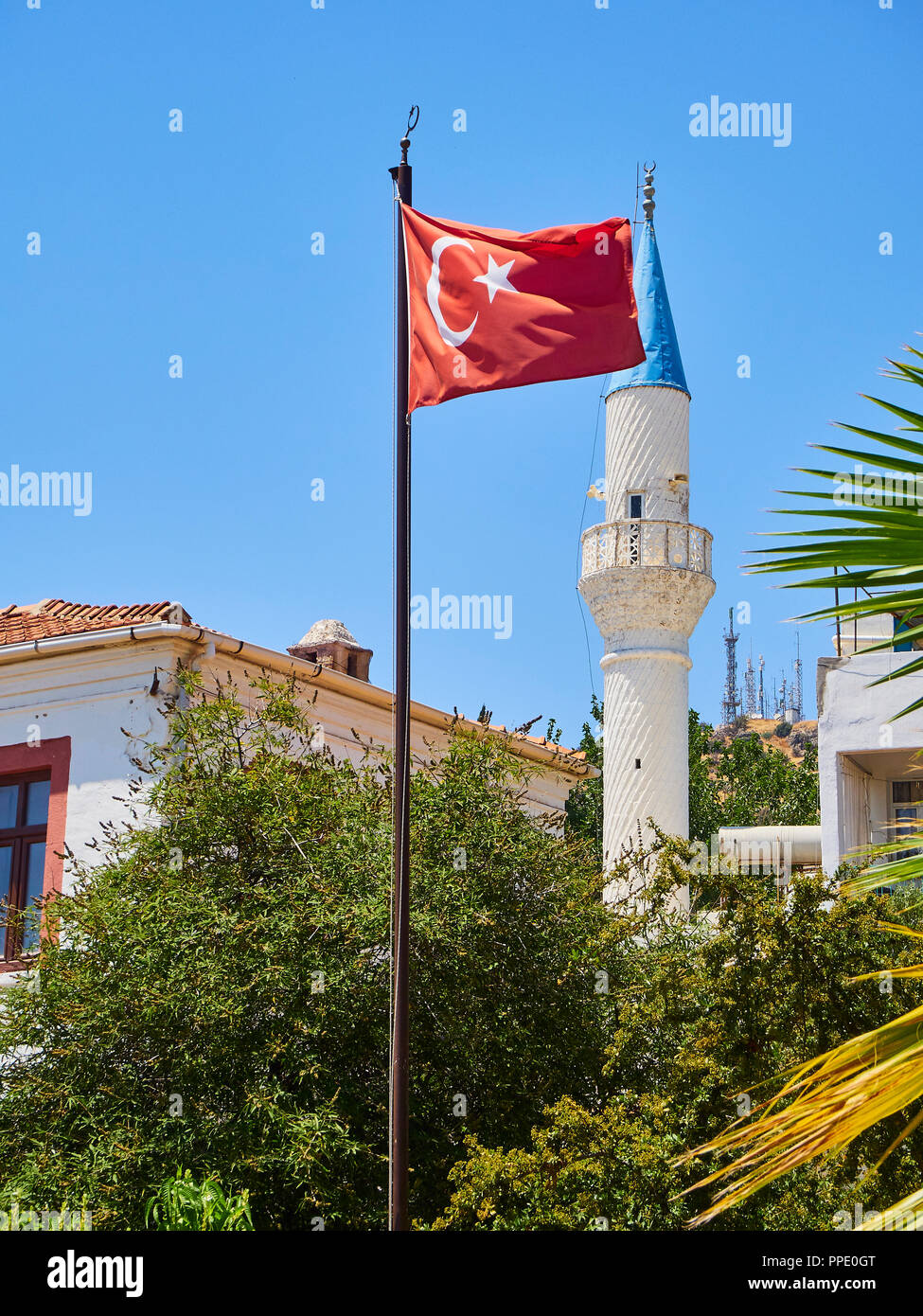 Minarett des Kelerlik Mahallesi Cami Moschee mit der offiziellen Flagge der Republik Türkei winkend im Vordergrund. Stockfoto