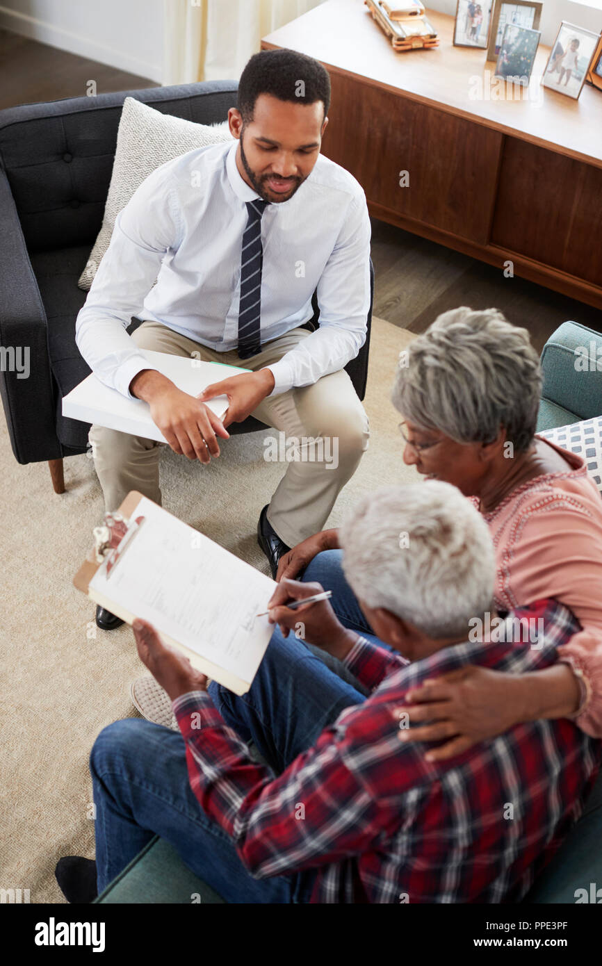 Senior Paar treffen mit männlichen Finanzberater zu Hause und Unterzeichnung des Dokuments Stockfoto