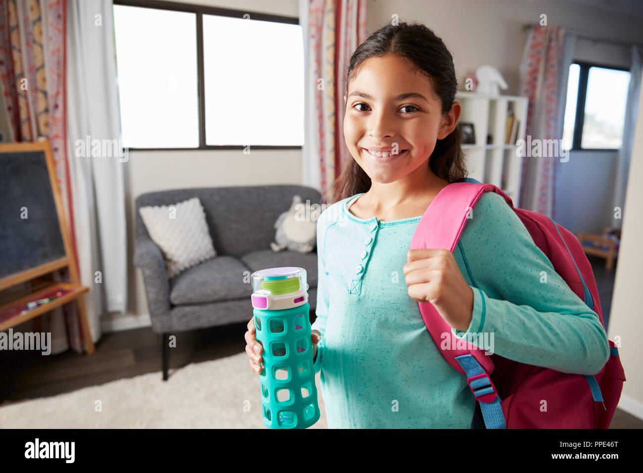 Portrait von Mädchen mit Rucksack im Schlafzimmer bereit, in die Schule zu gehen Stockfoto