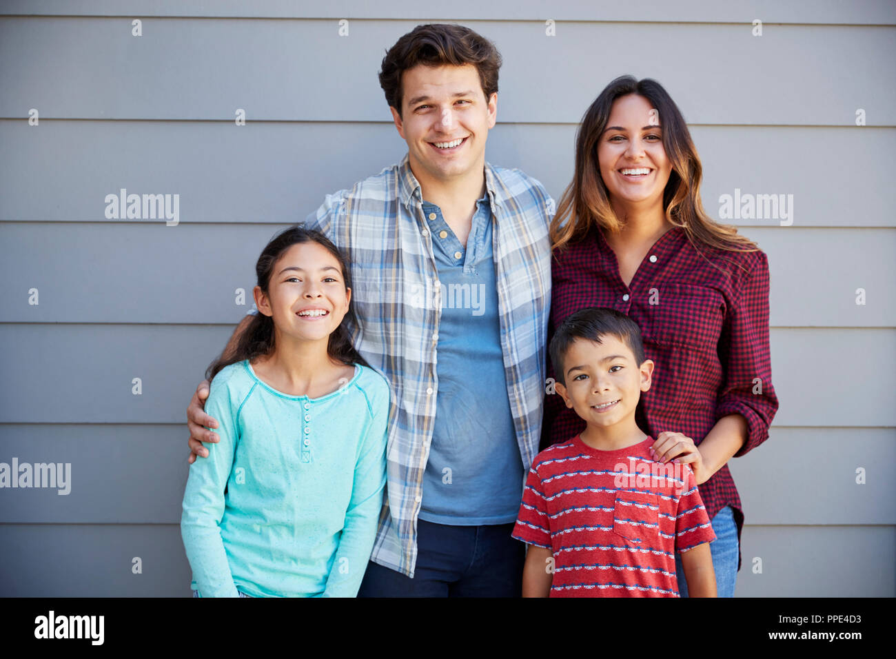 Portrait von Happy Family außerhalb Graue Schindeln Haus stehend Stockfoto