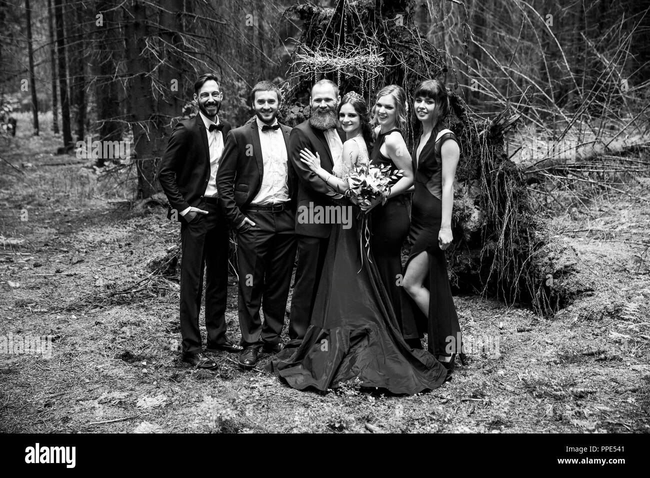 Schwarz-weiß-Foto im Retro-stil. Das Paar und die Zeugen im Hintergrund einer Hütte im Wald Stockfoto