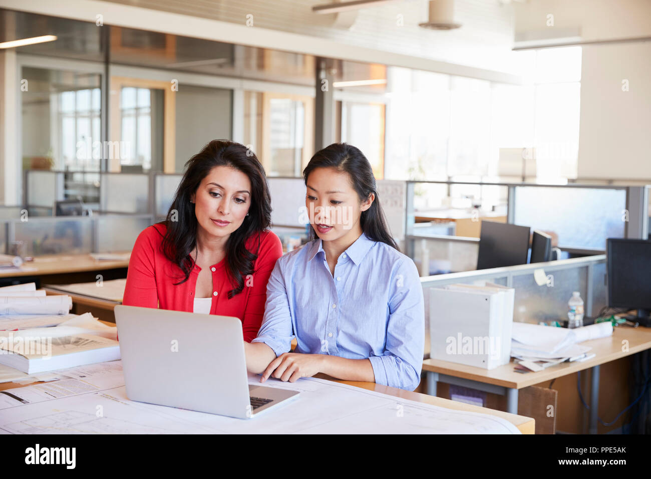 Zwei weiblichen Architekten mit einem Laptop in einem Großraumbüro Stockfoto