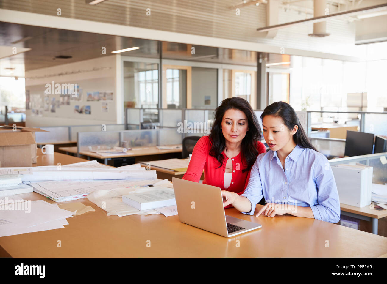 Zwei weiblichen Architekten mit einem Laptop in einem Großraumbüro Stockfoto