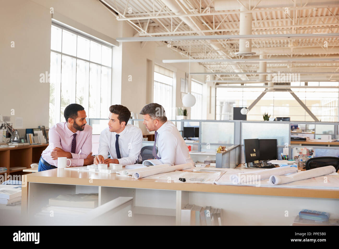 Drei männlichen Architekten in Diskussion in einem Großraumbüro Stockfoto
